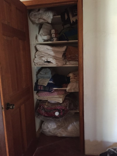 Linen closet before organizing and lighting.