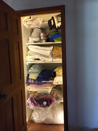 Linen closet with lighting before organizing
